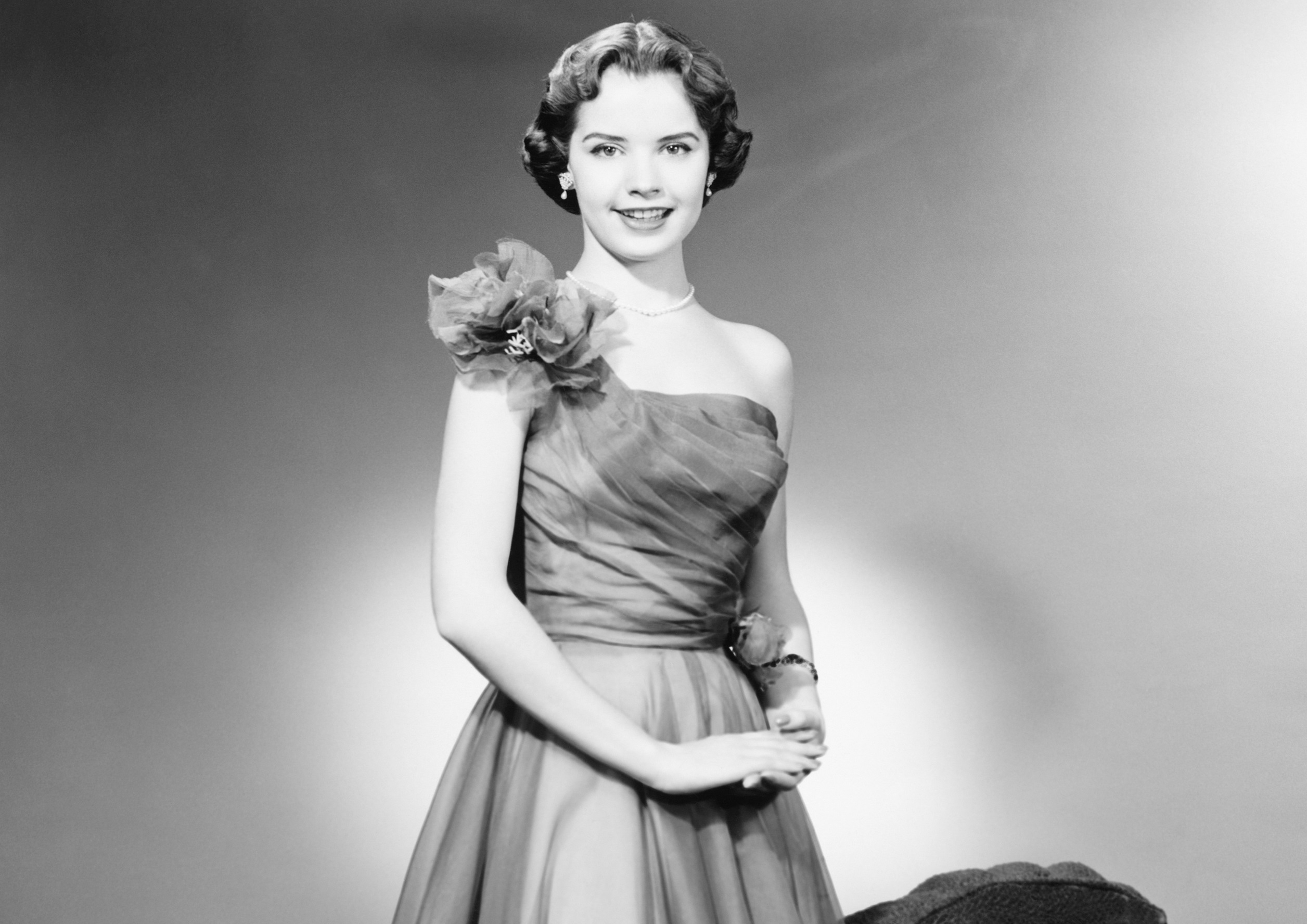 A black and white photo of a woman in a fancy dress